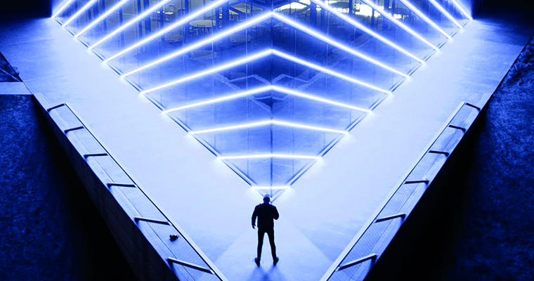 En man står framför en futuristisk byggnad.
